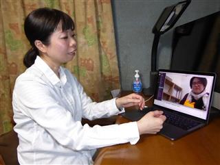 東京にいる同僚とノートパソコンでコミュニケーションを取る沢麻紀さん＝大阪府枚方市