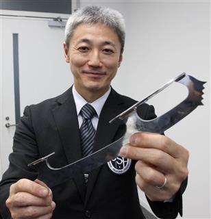 ブレードの試作品を手にする県スケート連盟の伝井達理事長