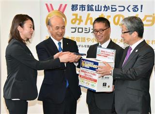 回収ボックスに携帯電話を入れる田中雅美さん（左端）ら＝２８日午前、東京・丸の内