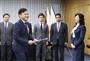 野田聖子総務相（右端）から受け取った携帯電話事業参入の認定書を手に、笑顔を見せる楽天の三木谷浩史会長兼社長＝９日午後、総務省