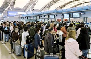 混雑する関西国際空港の航空カウンター。来年１月から国際観光旅客税が導入される
