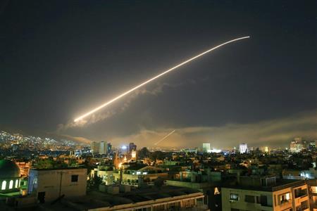 シリアへの軍事攻撃が始まり、首都ダマスカス上空を飛ぶミサイル＝１４日、ダマスカス（ＡＰ）