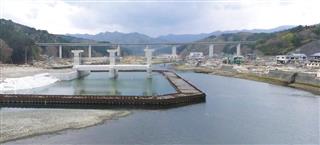 織笠川の水門工事現場。水門（左奥）を囲んでいるのがインプラント工法による「鋼矢板二重締切」。締切の右の川沿いの堤防は津波で破壊されている＝岩手県山田町