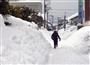 除雪された雪が身長を超える高さまで積まれた歩道＝福井市内
