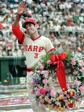 １９８７年６月、試合終了後、「２１３１」を記した花輪を手に観客の祝福に応える衣笠祥雄選手＝広島