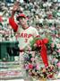 １９８７年６月、試合終了後、「２１３１」を記した花輪を手に観客の祝福に応える衣笠祥雄選手＝広島