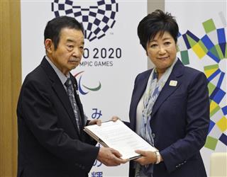 業界団体の代表から要望書と約１８万人分の署名を受け取る東京都の小池百合子知事（右）＝２４日、東京都庁