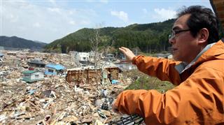 津波で被害を受けた岩手県釜石市で状況を説明する片田教授。堤防が破壊され住宅地が浸水した=平成23年5月 津波で被害を受けた岩手県釜石市で状況を説明する片田教授。堤防が破壊され住宅地が浸水した=平成23年5月
