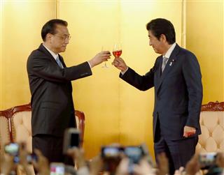 日本の経済界などが開催した歓迎レセプションで、安倍首相（右）と乾杯する中国の李克強首相＝１０日午後、東京都内のホテル