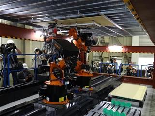 清水建設が開発した自律型パネル貼りロボット「ＲＯＢＯ－ＢＵＤＤＹ」。片腕（写真奥）でパネルを支え、もう一方の腕でパネルを留めていく＝東京都江東区