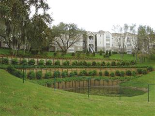 手間の陥没地点と後方のアパートとの間に杭の連続壁がつくられた＝米国フロリダ州