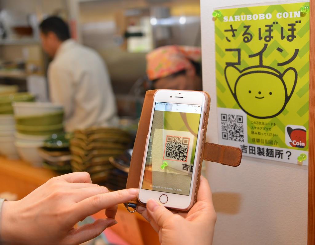 専用二次元コードを店内に掲示し、アプリを立ち上げたスマートフォンで二次元コードを読み込み、金額をスマホに打ち込むだけで決済が完了する「さるぼぼコイン」