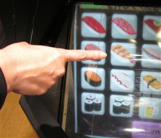 回転寿司店用のデモ機。メニューは空中に表示され、画面に触れることなく衛生的に注文できる