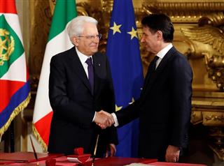 イタリア新首相に指名され、宣誓式に臨んだジュセッペ・コンテ氏（右）と握手するマッタレッラ大統領＝１日、ローマ（ロイター）