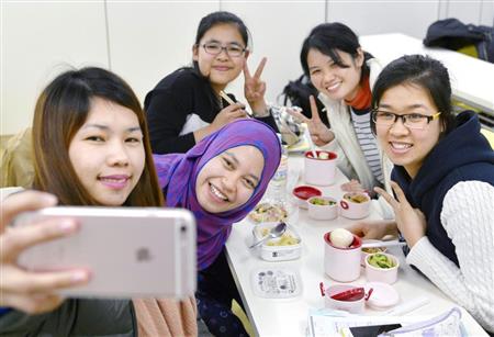 介護福祉士の国家試験に向けた講習で、休憩中に記念写真を撮る外国人の候補生。ベトナム、フィリピン、インドネシアから来日している＝大阪市