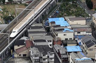 大阪北部地震で被災した家屋には、雨に備えブルーシートで覆われていた＝１９日午前、大阪府高槻市（本社ヘリから）