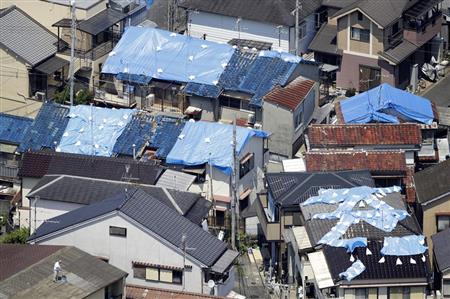 地震で屋根瓦が崩れ、ブルーシートが掛けられた住宅＝２４日、大阪府高槻市