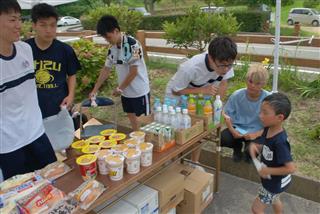 平公民館を訪れた市民に食料や生活用品を提供する高校生＝１１日、愛媛県大洲市