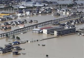 豪雨による川の堤防決壊で浸水した倉敷市立真備中（画面右側中央）＝８日、岡山県倉敷市真備町地区（共同通信社ヘリから）