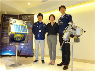 人工流れ星のもととなる「流星源」を放出する装置（右）とそれを搭載する人工衛星と並ぶＡＬＥの岡島礼奈ＣＥＯ（右から２人目）ら＝東京都港区