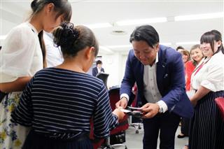 ファミリーデーに参加した子供に挨拶するプレシャスパートナーズの高崎誠司社長＝東京都新宿区（同社提供）