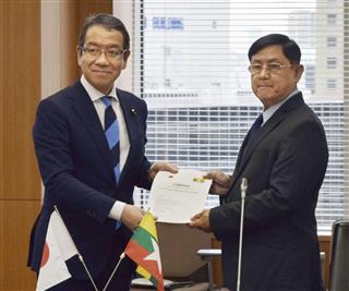 ミャンマーの政府関係者(右)に保険の支援計画を手渡す越智隆雄内閣府副大臣=6月、東京都千代田区 ミャンマーの政府関係者(右)に保険の支援計画を手渡す越智隆雄内閣府副大臣=6月、東京都千代田区