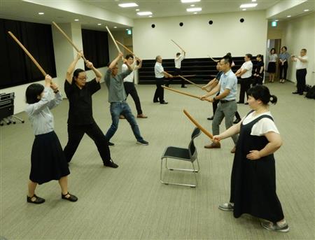 講師の大内千里さん（左から２人目）から木刀の使い方を指導される大阪府池田市職員