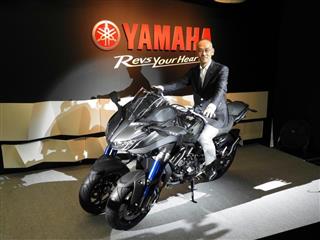 大型三輪バイクにまたがりアピールするヤマハ発動機の日高祥博社長＝東京都台東区