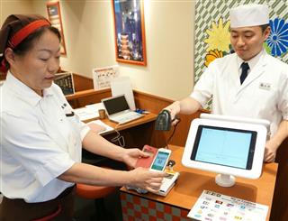 スマホアプリを使った支払いのデモを実演する「大江戸てんや」のスタッフら＝１日、東京都台東区