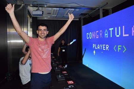 「スペースインベーダーギガマックス」をクリアしてガッツポーズをとる外国人男性