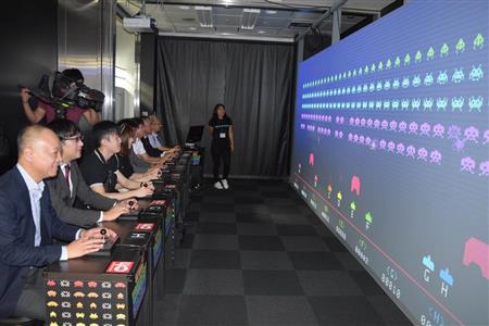 最大８人が並んで「スペースインベーダーギガマックス」を楽しむプレーヤーたち