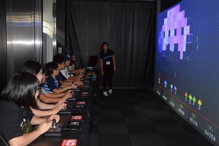 一列に並んで「スペースインベーダーギガマックス」を楽しむプレーヤーたち