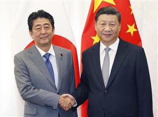 会談で握手する中国の習近平国家主席（右）と安倍首相＝９月１２日、ロシア・ウラジオストク（共同）