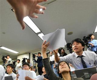 会見前、不正装置が使用された物件に関する資料を受け取る報道関係者ら＝１９日午後、東京都千代田区の国土交通省