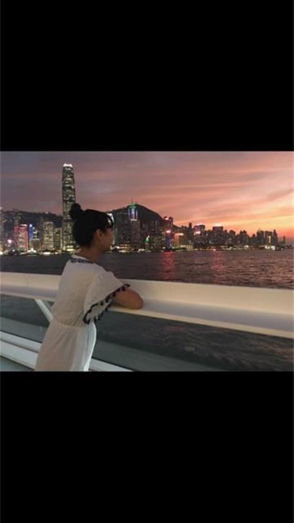 笹子さん。香港の夕景をバックに