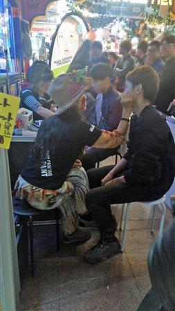 フェースペイントのサービスを受けるお客