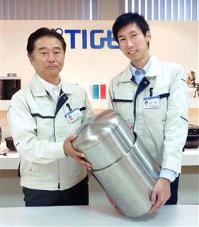 小型回収カプセルに搭載した断熱容器の見本を持つ、タイガー魔法瓶の中井啓司さん（左）ら＝２２日、大阪府門真市