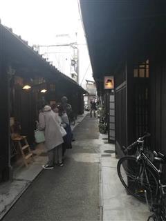 休日限定でオープンするあじき路地の店の前で立ち止まる観光客ら＝京都市東山区