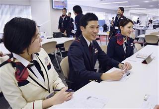 同僚と打ち合わせをする日本航空の客室乗務員、中村裕樹さん（中央）＝１１月、羽田空港