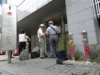 ケフィア事業振興会の「公示書」をみる高齢者