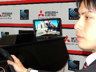 三菱電機の“気が利く車載技術”の実演。ドライバーの視線を検知し、反対側から歩行者が来ると電子ドアミラーで強調表示し、警告音を鳴らす 三菱電機の“気が利く車載技術”の実演。ドライバーの視線を検知し、反対側から歩行者が来ると電子ドアミラーで強調表示し、警告音を鳴らす