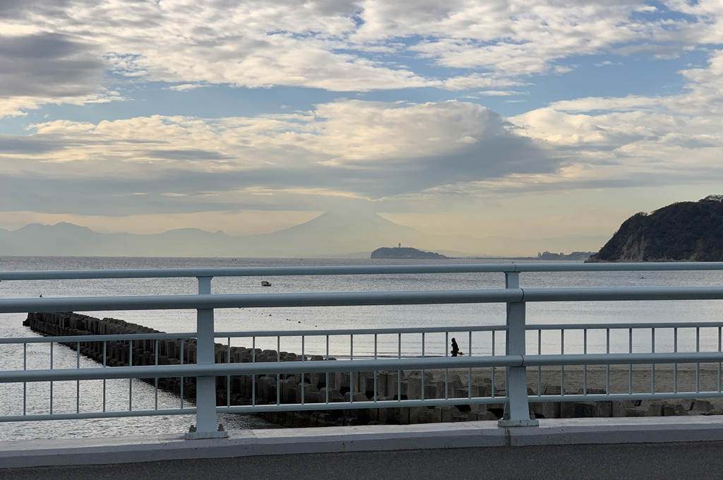ドライブ中の逗子海岸の景色。江の島の奥に富士山を望む