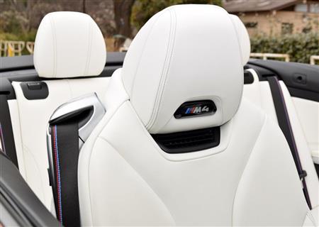 赤と青の「Ｍ」カラーを施したシートベルトとヘッドレストのエンブレム。ネック部分にはエアコンの吹き出し口がある