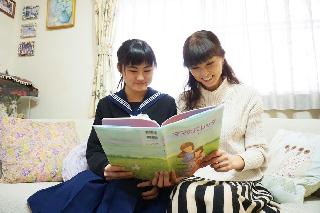 絵本「ママのバレッタ」をいっしょに読む田中聡子さん（右）と長女の沙羅さん