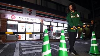 セブンーイレブン本木店で、営業時間短縮の実証実験が行われた。午前１時過ぎ、駐車場を閉鎖する店員＝２２日未明、東京都足立区（川口良介撮影）