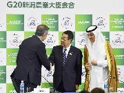 Ｇ２０農相会合後の記者会見を終え、出席者と握手する吉川農相（中央）＝１２日、新潟市