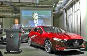 マツダの新型車「マツダ３」を発表する丸本明社長＝２４日、東京都品川区（飯田英男撮影）