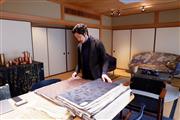 見本台帳を手に西陣織の伝統の技を語る細尾１２代目の細尾真孝さん＝京都市上京区