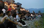 夕暮れどき、河川敷に座ってくつろぐ人たち