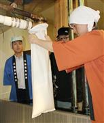 曙酒造で“搾り”作業に参加する新庄信用金庫の高橋良征さん（右）。左は三条信用金庫の中山芳郁さん＝６月２３日、福島県会津坂下町
